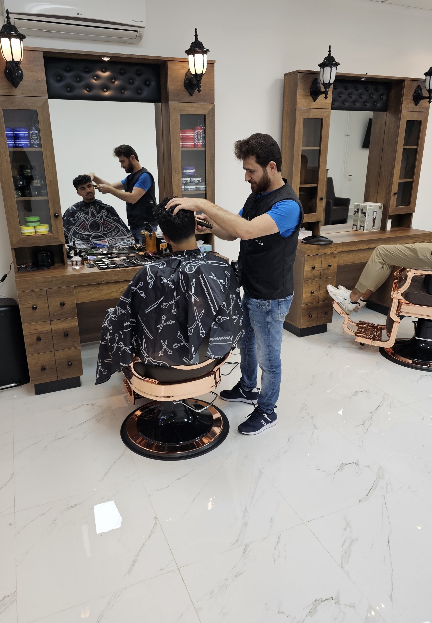 De barbier aan het werk bij een spiegelkast met lantaarns, op de achtergrond een tweede stoel